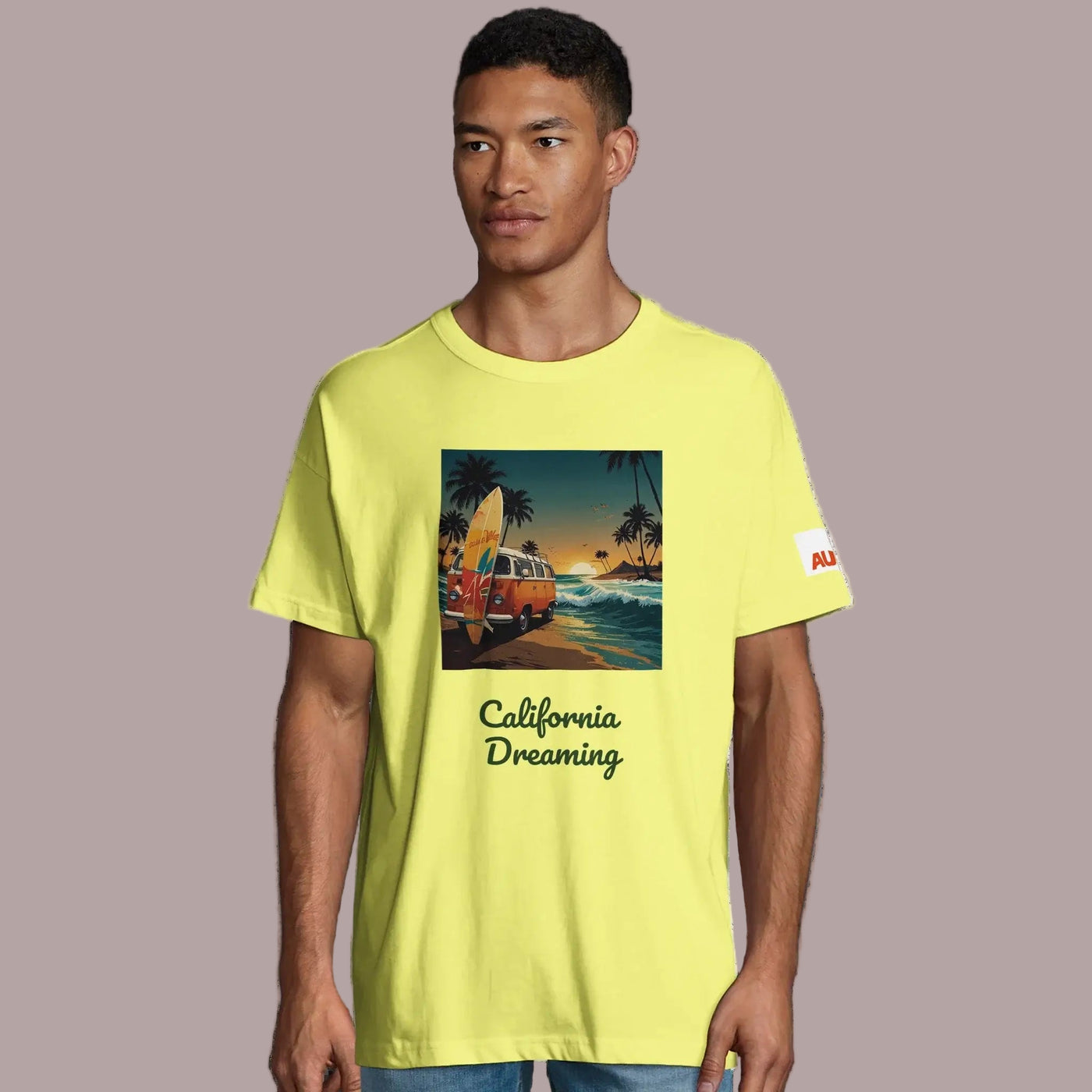 Camiseta Oversize Algodón Orgánico en color amarillo con diseño California Dreaming y surfero en la playa.